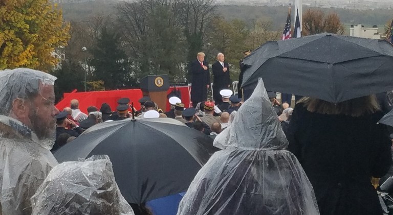 Trump speaks at military cemetery without umbrella in soaking rain