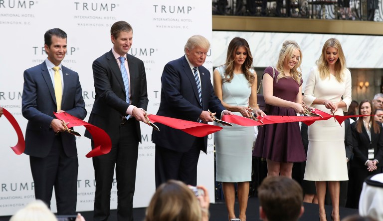Republican presidential candidate Donald Trump, together with his family, from left, Donald Trump Jr., Eric Trump, Trump, Melania Trump, Tiffany Trump and Ivanka Trump, cut the ribbon during the grand opening of Trump International Hotel in Washington, Wednesday, Oct. 26, 2016.