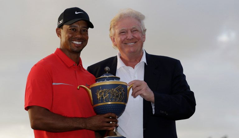 Tiger Woods stands with Donald Trump as he holds the Gene Serazen Cup for winning the Cadillac Championship golf tournament Sunday, March 10, 2013, in Doral, Fla. Woods won with a score 19-under-par 269.