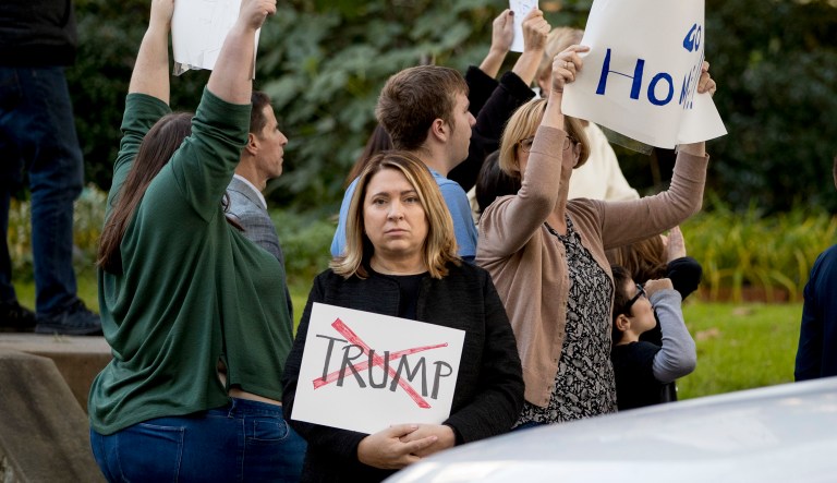 Protesters stand down the street from the Tree of Life Synagogue in Pittsburgh, Tuesday, Oct. 30, 2018, as President Trump and first lady Melania Trump along with Ivanka Trump, the daughter of Trump, and Trump's White House senior adviser Jared Kushner visit following Saturday's shooting at the synagogue.