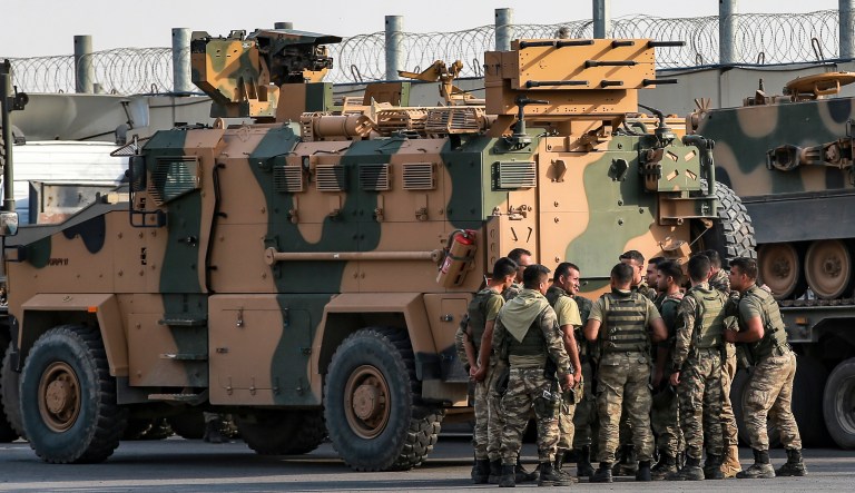 Turkish soldiers prepare to enter Syria aboard an armoured personnel carrier at the border with Syria in Karkamis, Gaziantep province, southeastern Turkey, Tuesday, Oct. 15, 2019. Turkey defied growing condemnation from its NATO allies to press ahead with its invasion of northern Syria on Tuesday, shelling suspected Kurdish positions near the border amid reports that Syrian Kurds had retaken a key town.