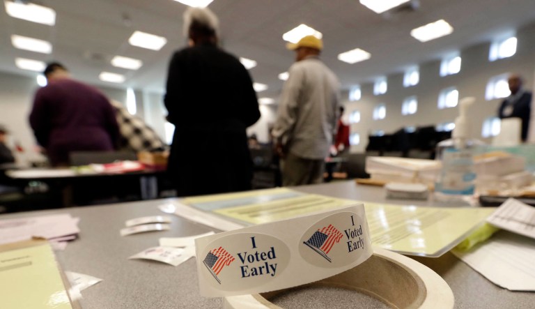 People register and cast their ballots during early voting at a polling place in Charlotte, N.C., Tuesday, Oct. 23, 2018. 