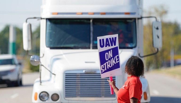 A striking plant worker blocks the passage of a truck outside the General Motor assembly plant in Bowling Green, Ky, Monday, Sept. 16, 2019. 