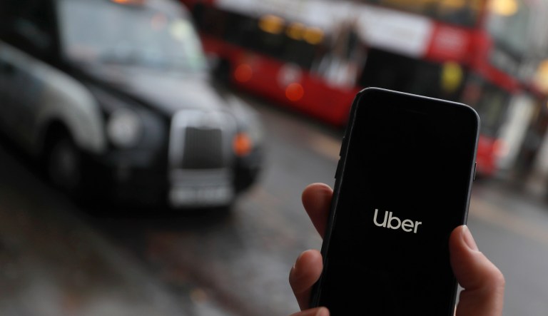 In this posed picture the Uber app is opened on a mobile phone in London, Monday, Nov. 25, 2019. Uber have lost their licence to operate in London but will continue to operate until they can appeal.