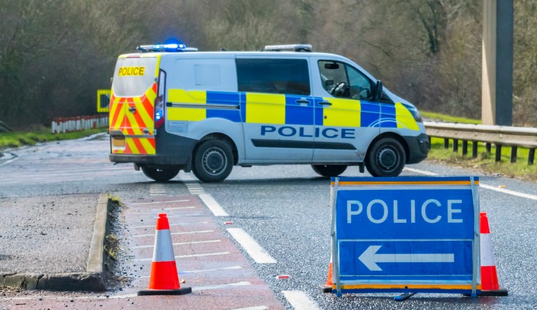 A UK police van on a closed road.
