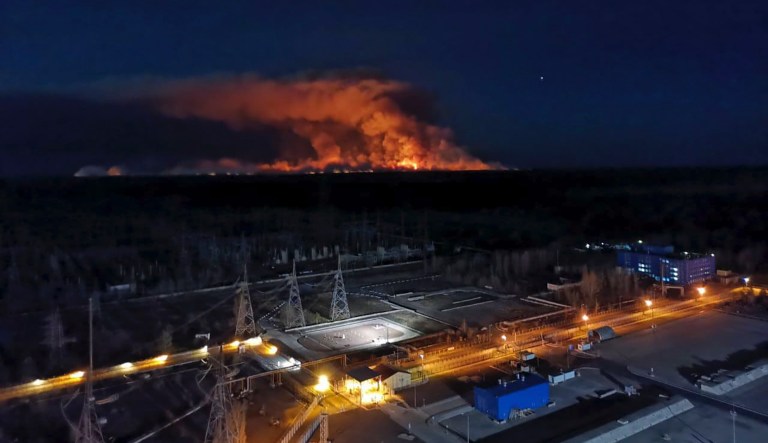 In this photo taken from the roof of Ukraine's Chernobyl nuclear power plant late Friday April 10, 2020, a forest fire is seen burning near the plant inside the exclusion zone.