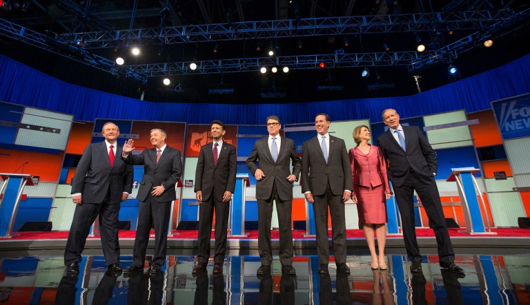 Republican presidential candidates from left, Jim Gilmore, Lindsey Graham, Bobby Jindal, Rick Perry, Rick Santorum, Carly Fiorina, and George Pataki take the stage for a pre-debate forum at the Quicken Loans Arena, Thursday, Aug. 6, 2015,  in Cleveland.