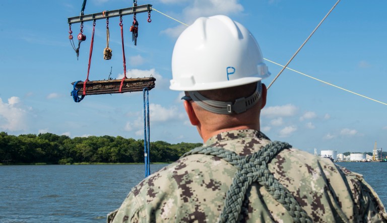 In a Friday, Aug. 14, 2015 photo provided by the US Navy, Chief Warrant Officer 3, Jason Potts, on scene commander for Task Element CSS Georgia, supervises as a piece of casemate, made of railroad ties and timber, which served as the outer layer of armor for CSS Georgia, is raised from the Savannah River in Savannah, Ga. Navy divers are working in conjunction with archeologists, conservationists, Naval History and Heritage Command and the U.S. Army Corps of Engineers in a project directed by Naval Sea Systems Command Supervisor of Salvage and Diving to salvage and preserve CSS Georgia.