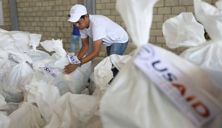 A Venezuelan volunteer places a bag of USAID humanitarian aid for storage at a warehouse next to the Tienditas International Bridge, near Cucuta, Colombia, on the border with Venezuela, Friday, Feb. 8, 2019.