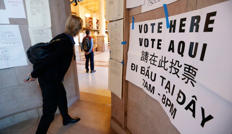 A woman peers into a polling station at the main branch of the Boston Public Library in Boston, Tuesday, Nov. 8, 2016.