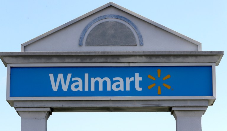 FILE - In this Tuesday, Sept. 3, 2019, file photo, a Walmart logo forms part of a sign outside a Walmart store, in Walpole, Mass. Walmart is rolling out a health care pilot program for its employees that will come up with a curated list of high quality providers but offer fewer choices than under the current plan.