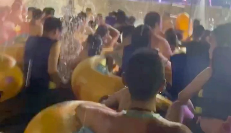 This image made from an Aug 3, 2020 video shows crowd gather in a pool as they watch performers on a stage at Wuhan Maya Beach Water Park in Wuhan, central China. For more than two months, the 11 million residents of Wuhan endured a strict lockdown as coronavirus raced around the city. Now, some are letting loose en masse at rocking nighttime pool parties at the popular amusement park chain. The park reopened in late June, and the crowds have picked up in August.