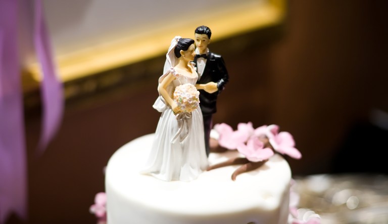 Bride and Groom Figurines on Top of Wedding Cake.