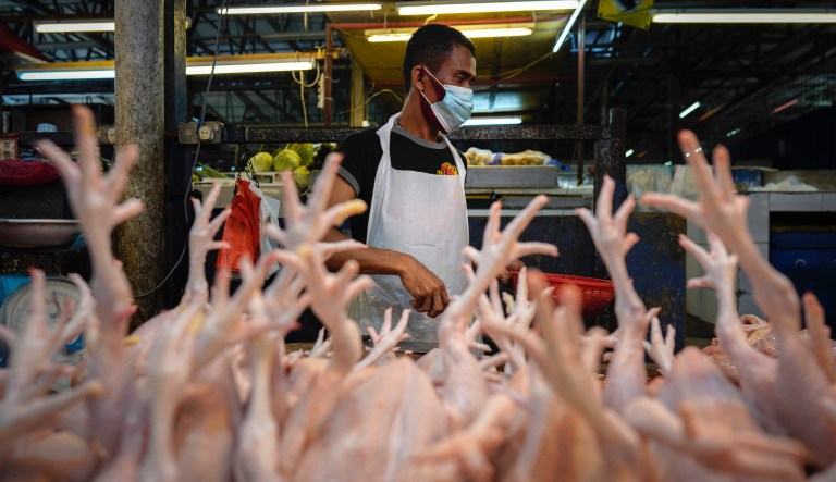 Poultry seller wearing face mask preparing at wet market in downtown Kuala Lumpur, Malaysia, Friday, April 24, 2020. Malaysia, along with neighboring Singapore and Brunei, has banned popular Ramadan bazaars where food, drinks and clothing are sold in congested open-air markets or road-side stalls. The bazaars are a source of key income for many small traders, some who have shifted their businesses online.