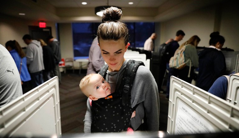 Kristen Leach votes with her six-month-old daughter, Nora, on election day in Atlanta, Tuesday, Nov. 6, 2018. 
