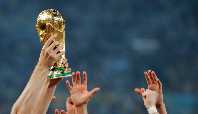 FILE - In this Sunday, July 13, 2014 file photo, German players reach out to touch the trophy after the World Cup final soccer match between Germany and Argentina at the Maracana Stadium in Rio de Janeiro, Brazil. Morocco will bid to host the 2026 World Cup, giving a joint bid from North America some competition. The Morocco Football Federation announced its intention to bid on Friday, Aug. 11, 2017 the deadline for countries to express their interest.