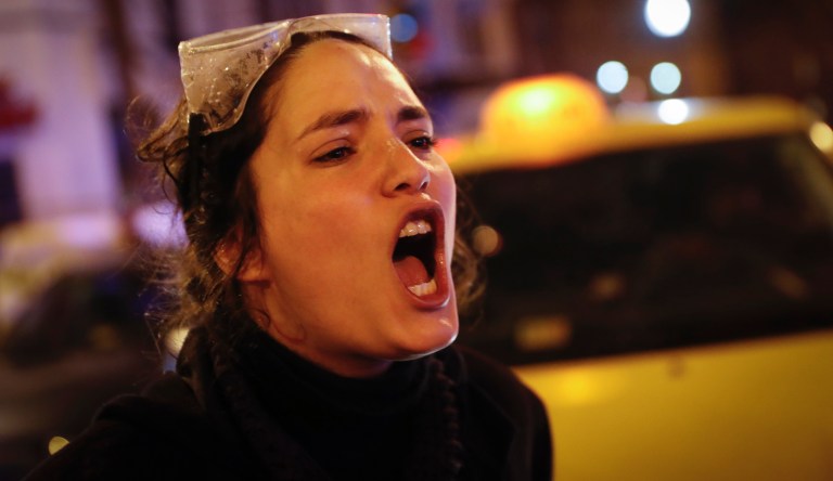 A protester yells at riot police in Washington, Friday, Jan. 20, 2017, after the inauguration of President Donald Trump. 