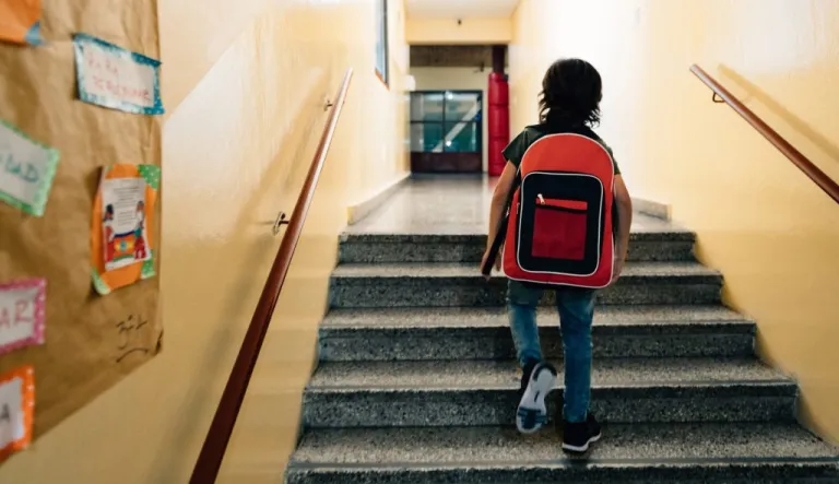 Elementary age student walks to class through school corridors.