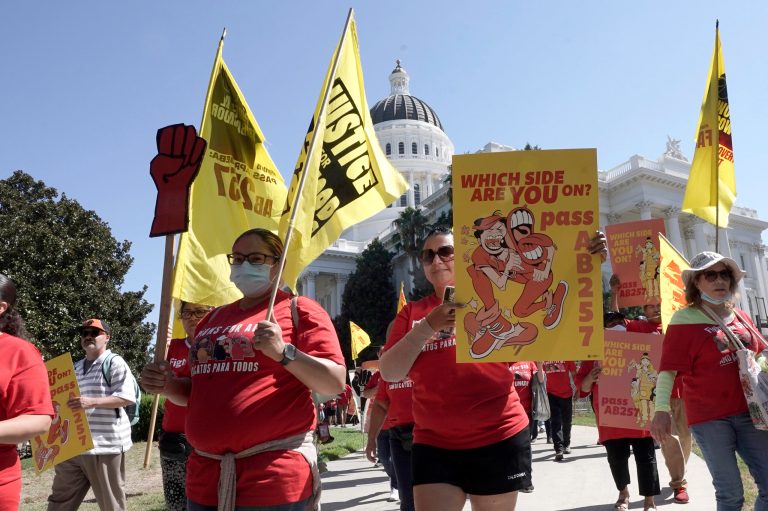 Fast food workers and supporters march past California's capitol in Sacramento in 2022 to rally around a $20 minimum wage effort introduced in the state legilsautre. On Jan. 1, 2024, 22 U.S. states implemented new minimum wage increases, affecting an estimated 10 million workers nationwide. (AP/Rich Pedroncelli)