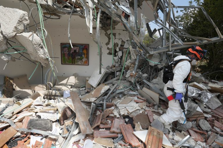 An Israeli soldier walks by a house destroyed by Hamas militants in Kibbutz Be'eri on Wednesday, Oct. 11, 2023.