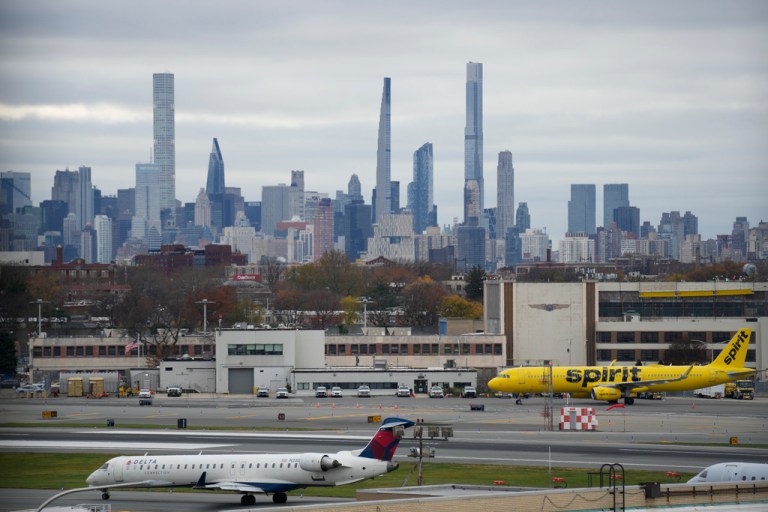 The New York City skyline is seen behind planes waiting to take off at LaGuardia Airport in New York, Wednesday, Nov. 22, 2023. 