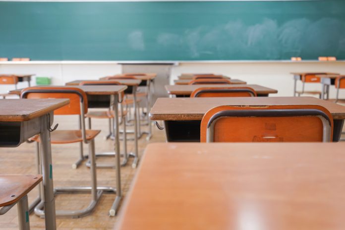 Classroom with brown desks and a green chalkboard