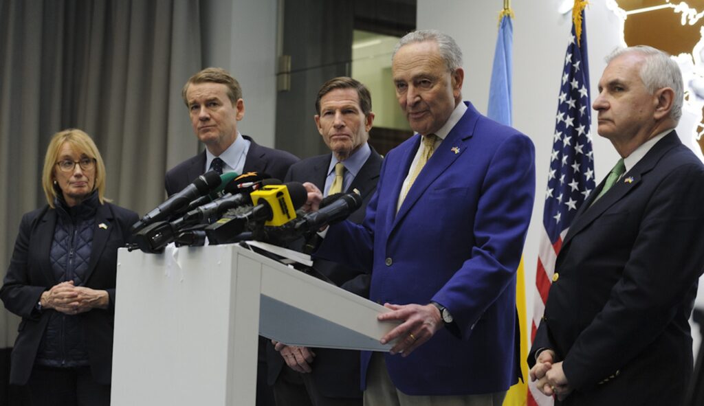 Left to right: Sen. Maggie Hassan (D-NH), Sen. Michael Bennet (D-CO), Sen. Richard Blumenthal (D-CT), Charles Schumer (D-NY), and Sen. Jack Reed (D-RI) answer media questions in Lviv, Ukraine, Friday, Feb. 23, 2024. (AP Photo/Mykola Tys)