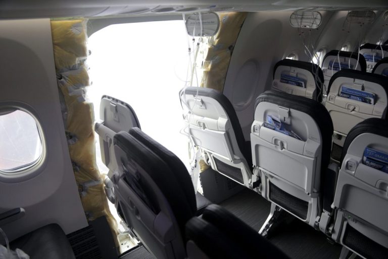 This photo released by the National Transportation Safety Board shows a gaping hole where the paneled-over door had been at the fuselage plug area of Alaska Airlines Flight 1282