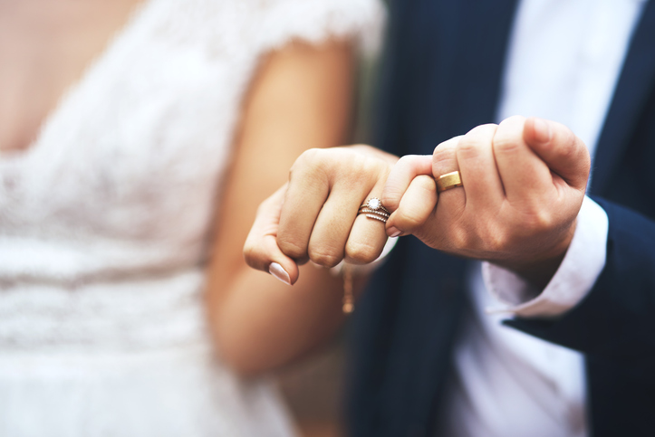Cropped shot of an unrecognizable newlywed couple doing a pinky swear gesture on their wedding day.