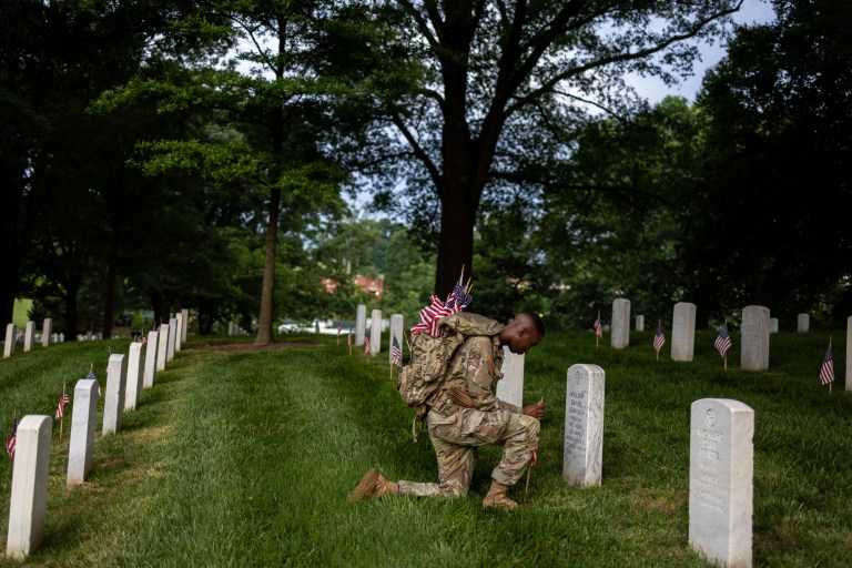 Soldiers place flags at Arlington National Cemetery to honor fallen heroes