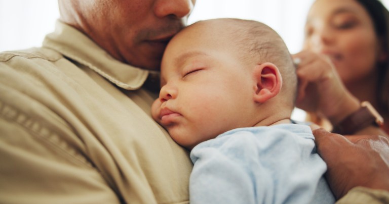 A baby sleep on a father's chest for rest, childhood development, dreams, or safety.