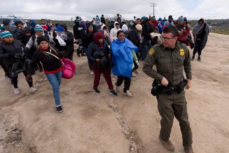 Illegal immigrants seeking asylum walk behind a Border Patrol agent to be processed after crossing the border, April 25, 2024.