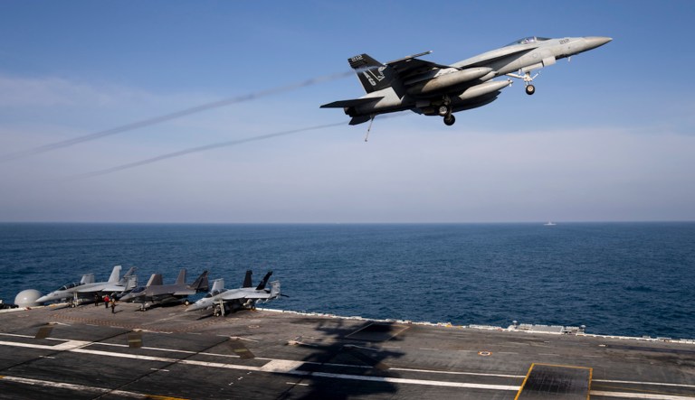 An F/A-18 Super Hornet fighter jet flies over the deck of the nuclear-powered aircraft carrier USS George Washington during joint exercises, off the coast of Argentina, Thursday, May 30, 2024.