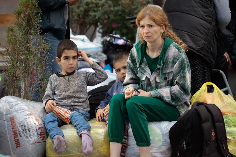 Ethnic Armenians from Nagorno-Karabakh sit after arriving in Armenia's Goris in Syunik region, Armenia, Thursday, Sept. 28, 2023.