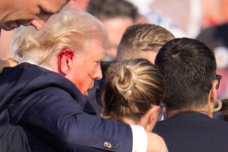 Former President Donald Trump, Republican presidential candidate, is surrounded by Secret Service agents as he is helped off the stage at a campaign rally in Butler, Pennsylvania, Saturday, July 13, 2024. (AP Photo/Gene J. Puskar)