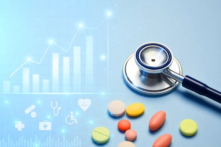 Healthcare business graph and data of medical business growth and a stethoscope with multi colored pills.