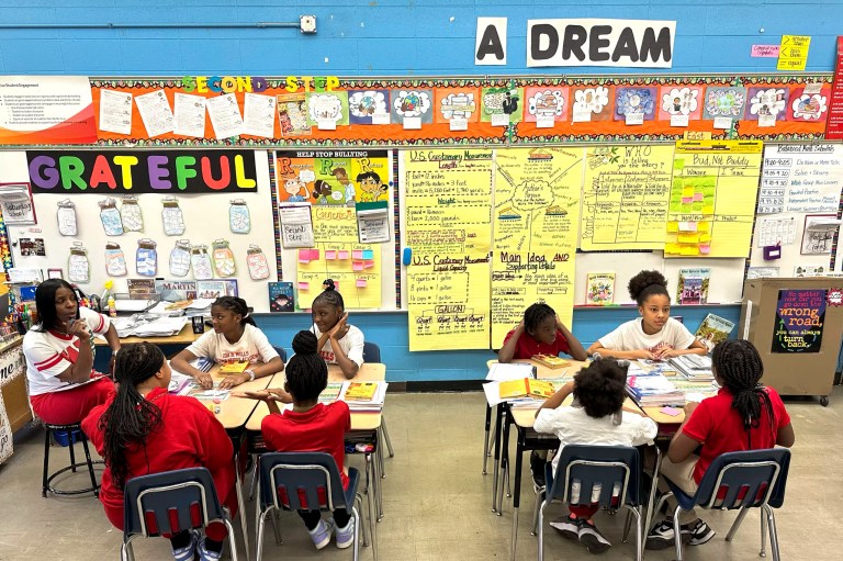 Wells Preparatory Elementary School teacher Charlotte Owens, left, works with her fifth grade students during the literature segment of their day, Friday, March 8, 2024, in Chicago. In Chicago Public Schools, the average reading score went up by the equivalent of 70% of a grade level from 2022 to 2023. Math gains were less dramatic, with students still behind almost half a grade level compared to 2019. Chicago officials credit the improvement to changes made possible with nearly $3 billion in federal relief.