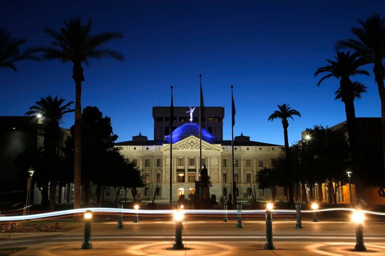 The blur of car lights zip past the Arizona Capitol as the dome is illuminated on April 15, 2020, in Phoenix.