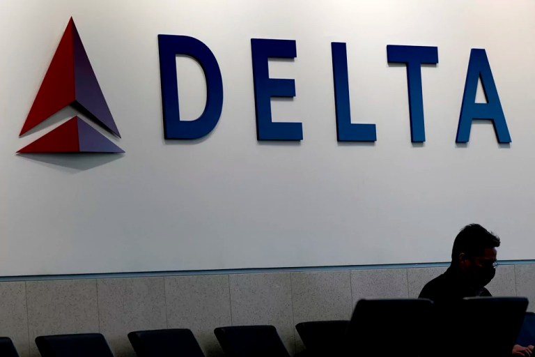 A man waits for a Delta Airlines flight at Hartsfield-Jackson International Airport in Atlanta on Jan. 7, 2022. Delta said it plans to cap the number of entries to its Sky Clubs starting Feb. 1, 2025 for holders of the American Express Platinum Card as well as the Delta Reserve American Express Card.