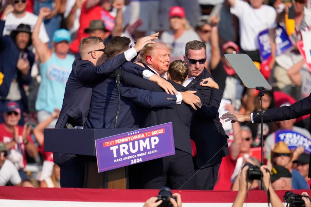 Trump is helped off the stage at a campaign event in Butler, Pa., after surviving an assassination attempt on Saturday, July 13, 2024. 
