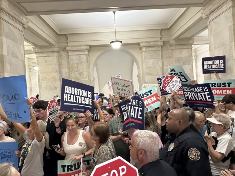 Supporters and opponents of a proposed ballot measure to scale back Arkansas's abortion ban hold signs outside the old Supreme Court chamber at the state Capitol in Little Rock, Arkansas, July 5, 2024.