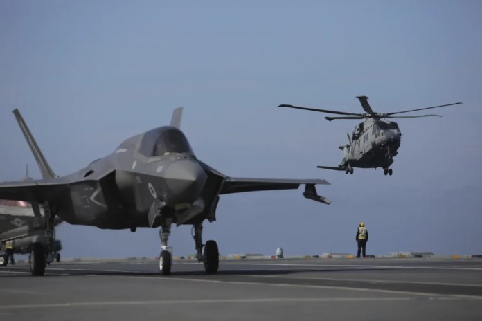 Military personnel direct F-35 jets and helicopters on the deck of the aircraft carrier HMS Queen Elizabeth as it participates in the NATO Steadfast Defender 2021 exercise off the coast of Portugal, Thursday, May 27, 2021.