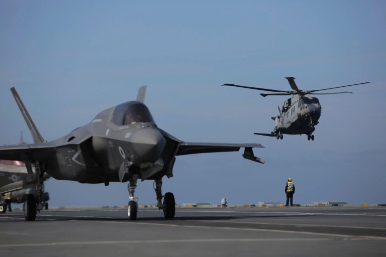 Military personnel direct F-35 jets and helicopters on the deck of the aircraft carrier HMS Queen Elizabeth as it participates in the NATO Steadfast Defender 2021 exercise off the coast of Portugal, Thursday, May 27, 2021.
