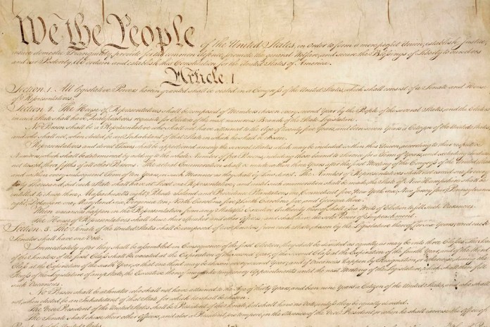 This photo made available by the U.S. National Archives shows a portion of the first page of the United States Constitution.