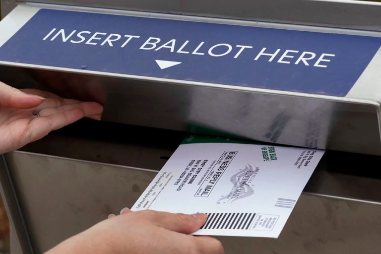 A Michigan voter inserts her absentee voter ballot into a drop box in Troy, Michigan, on Oct. 15, 2020. (AP Photo/Paul Sancya)
