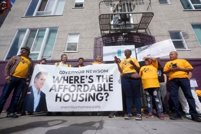 Merika Goolsby, of Alliance of Californians for Community Empowerment (AACE) board, middle right, speaks during a news conference and rally