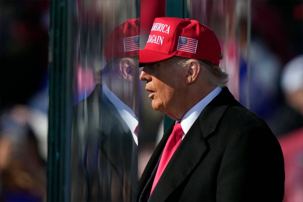 Republican presidential nominee former President Donald Trump is reflected in the bullet proof glass as he finishes speaking at a campaign rally in Lititz, Pa., Sunday, Nov. 3, 2024. (AP Photo/Matt Rourke)