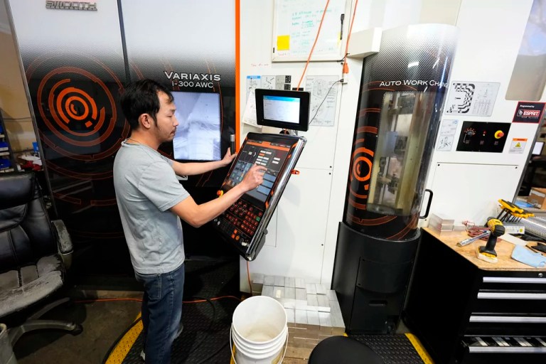 A worker at Reata Engineering and Machine Works programs a Mazak Variaxis machine used to make semiconductor pieces.