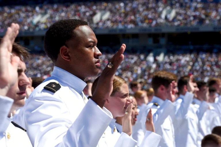U.S. Naval Academy midshipmen raise their right hands as they are commissioned as ensigns in the U.S. Navy during the academy's graduation and commissioning ceremony, Friday, May 24, 2019, in Annapolis, Maryland.