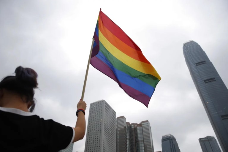 A participant holds a rainbow flag.
